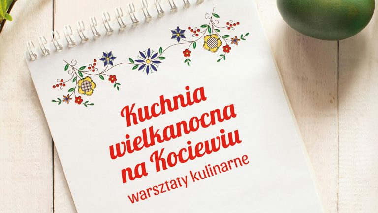 Biała kartka leży na białym, drewnianym stole. Na kartce, pośrodku napis "Kuchnia wielkanocna na Kociewiu warsztaty kulinarne", nad napisem rysunek haftu kociewskiego- stylizowane kwiaty w kolorach żółtym, niebieskim, pomarańczowym, zielonym.