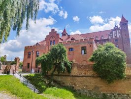Widok na Dom Bramny w Gniewie. W tle zamek krzyżacki.